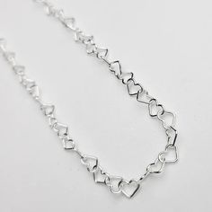 This sweet heart bracelet comes in sterling silver and 14k yellow gold so it makes for a lasting keepsake. Featuring a chain made of dainty little heart shaped links that measure approximately 3.4mm wide. Perfect as a gift or treat yourself, the bracelet is adjustable in size as you can easily make it a smaller fit by attaching the clasp to any link on the chain. Secures with an easy-to-use lobster clasp and the longest fit is 7.5 inches. This chain is also offered in our permanent jewelry line. Dainty Sterling Silver Chain Bracelet For Valentine's Day, Valentine's Day Dainty Sterling Silver Chain Bracelet, Dainty Sterling Silver Heart Bracelet, Adjustable Delicate Sterling Silver Heart Bracelet, Dainty Heart-shaped Sterling Silver Bracelet, Heart-shaped Adjustable Chain Bracelet For Anniversary, Valentine's Day Sterling Silver Bracelets With Adjustable Chain, Sterling Silver Bracelet With Heart Charm For Gift, Dainty Sterling Silver Heart Bracelet With Adjustable Chain