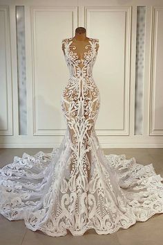 the back of a wedding dress on display in front of a white wall and floor