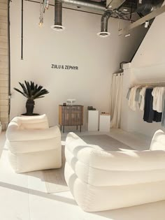 a room filled with white furniture and lots of windows