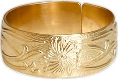 a gold bracelet with flowers and leaves engraved on the side, in front of a white background