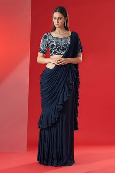 Navy blue pre-draped saree with ruffled panels. Paired with hand embroidered blouse with floral and geometric motifs.
Component: 2
Pattern: Embroidered
Type Of Work: Floral,geometric
Neckline: Sweetheart
Sleeve Type: Short
Fabric: Georgette crepe and satin
Color: Blue
Other Details: 
Closure: Back hook opening
Ruffle saree
Floral,geometric motifs
Occasion: Sangeet - Aza Fashions Hand Embroidered Blouse, Draped Saree, Saree Floral, Ruffle Saree, Drape Saree, Saree Designs Party Wear, Desi Style, Blue Saree, Geometric Motifs