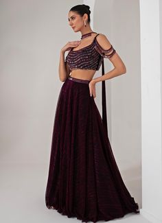 This stunning Black Platinoir Crepe Embellished Lehenga Set exudes modern elegance and glamour. Crafted from luxurious platinoir crepe, the black lehenga features a dramatic full-length skirt with all-over metallic brazen fall detailing, adding a shimmering effect with every movement. The crystal-embroidered waistband accentuates the waist, offering a refined silhouette. Teamed with a cold shoulder blouse, the ensemble reaches new heights with its halo crystal tassel embellishments, delivering a unique and stylish twist. The look is completed with a choker-style embellished dupatta, perfectly complementing the outfit with a sophisticated touch. Ideal for Cocktail parties, Sangeet nights, or evening events, this lehenga set is designed for those who wish to make a bold and fashionable state Fitted Georgette Evening Skirt, Evening Fitted Georgette Skirt, Festive Floor-length Pre-draped Saree For Gala, Festive Floor-length Embellished Skirt, Embellished Floor-length Festive Skirt, Party Wear Pre-draped Saree For Gala, Floor-length, Floor-length Pre-draped Saree For Gala, Festive Evening Pre-draped Maxi Saree, Festive Maxi-length Pre-draped Saree For Evening