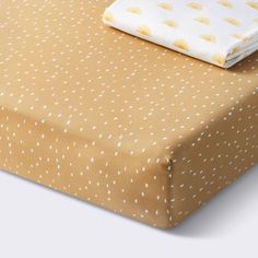 a sheet that is laying on top of a bed with polka dot print and yellow sheets