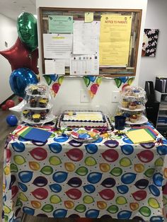 a table covered with lots of food and balloons