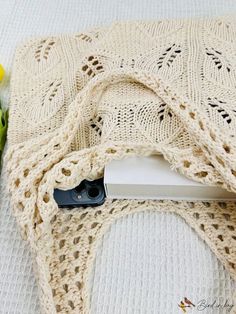 a crocheted table cloth with flowers on it next to a pair of scissors