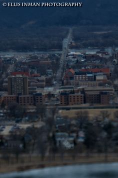 an aerial view of a city with lots of buildings and trees in the foreground