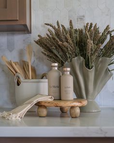 two bottles and some wooden utensils on a counter