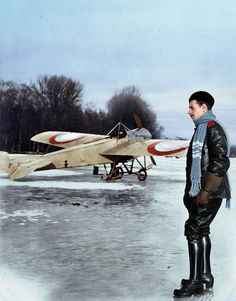 a man standing in the snow next to an airplane