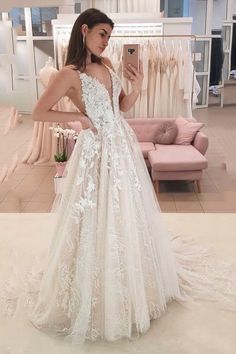 a woman is taking a selfie in her wedding dress at the bridal shop