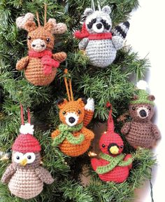 crocheted christmas ornaments are hanging from a pine tree with red and green decorations