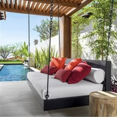 a bed sitting under a wooden roof next to a swimming pool