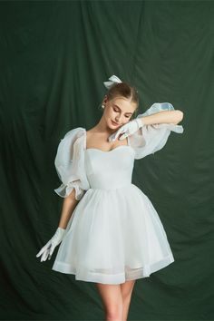 a woman in a white dress and gloves