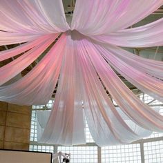 the ceiling is decorated with pink and white draping