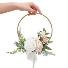 a hand holding a hoop with flowers in it