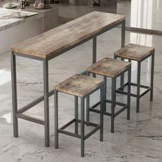 three stools and a table in a room with marble flooring on the walls