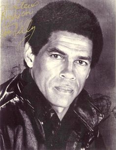 a black and white photo of a man wearing a leather jacket with writing on it