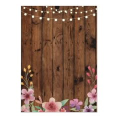 a wooden wall with flowers on it and string lights hanging from the top of it