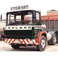 a green and white truck parked in front of a building