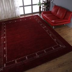 a living room with a red couch and rug