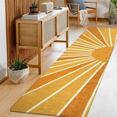 an orange and white rug in a living room next to a wooden table with a plant on it