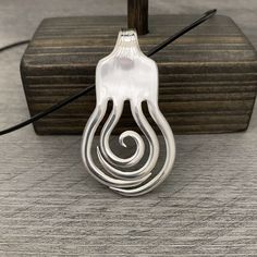 the pendant is designed to look like an octopus's tail, and has three spirals on each side