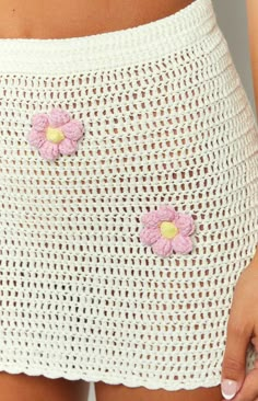 a close up of a person wearing a white skirt with pink flowers on the side