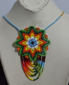 a beaded necklace with multicolored beads is displayed on a mannequin