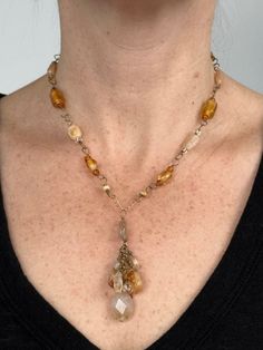 Handmade natural gemstone beaded necklace for person with a petite neck. This is an antiqued gold-tone single chain necklace comprised of polished citrine beads, golden glass beads, multicolored Japanese glass seed beads. This beaded necklace has a pendant of a cluster of citrine beads, multicolored Japanese glass seed beads and rutilated quartz and is closed with a antiqued gold-tone toggle-clasp. This is a golden, light yellow and amber colored handmade chunky necklace with beads and gemstones. Characterized by a free-spirited and unconventional look featuring natural materials, asymmetrical design, and a mix of colors and textures, this small bohemian chic necklace can be worn whenever someone wants to add a touch of boho flair to their outfit, whether it's for a casual daytime outing o Bohemian Yellow Brass Jewelry, Gold Wire-wrapped Dangle Beaded Necklaces, Gold Wire Wrapped Dangle Beaded Necklaces, Bohemian Wire Wrapped Beaded Necklaces With Czech Glass, Bohemian Wire Wrapped Czech Glass Beaded Necklace, Wire Wrapped Czech Glass Dangle Necklaces, Bohemian Crystal Necklaces With Faceted Beads For Healing, Bohemian Czech Glass Wire Wrapped Beaded Necklace, Bohemian Czech Glass Beaded Necklace With Wire Wrap