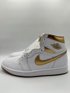 Elevate your sneaker game with these Nike Women's Air Jordan 1 Retro OG High sneakers in a metallic gold colorway. The high top shoe shaft style and leather upper material provide both support and style, while the iconic Nike Air Jordan logo adds a touch of retro charm. These sneakers are available in UK size 8.5, US size 11, and EU size 43, making them the perfect fit for any woman's shoe collection. Perfect for athletic activities or casual wear, these Nike Air Jordan 1 sneakers are a must-have for any fashion-forward woman. The style code Fd2596-107 ensures that these sneakers are on-trend and up-to-date, while the product line Air Jordan guarantees quality and durability. Add these sneakers to your collection today and step out in style! Air Jordan Logo, Air Jordan 1 Women, Jordan 1 Sneakers, High Top Shoe, Jordan Logo, Womens Air Jordans, Jordan 23, High Sneakers, Jordan Sneakers