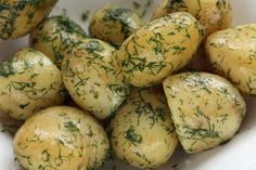 a white bowl filled with potatoes covered in herbs