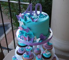 a multi layer cake with blue frosting and purple icing on the top tier