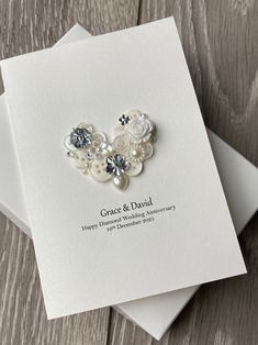 two wedding congratulations cards with buttons and pearls on them, sitting next to each other