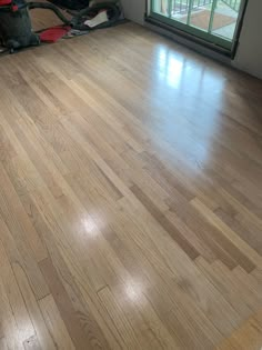 an empty living room with hard wood floors and sliding glass door that leads to patio