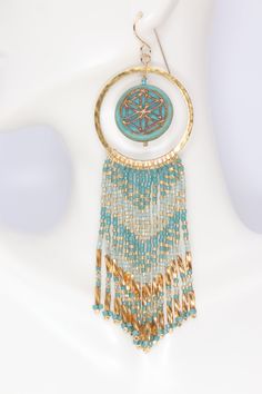 Experience the beauty and spirituality of the mandala with these boho turquoise & gold beaded hoop earrings. Handmade from Czech glass mandala beads, premium delica seed beads, hammered brass hoops, and gold filled ear wires. These fringed beauties will swing and sway their way into your heart with their eye catching mix of hex cut bugle beads, and seed beads in opaque, transparent, and metallic colors. They dangle and dance with the slightest movement. 4.25 inches long 1.25 inches wide Gold Fil Painted Desert, Hoop Earrings Handmade, Boho Turquoise, Desert Painting, Turquoise Boho, Brass Hoops, Hammered Brass, Bugle Beads, Beaded Hoop Earrings