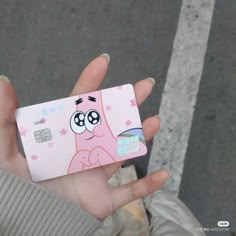 a person holding up a pink phone with cartoon characters on it