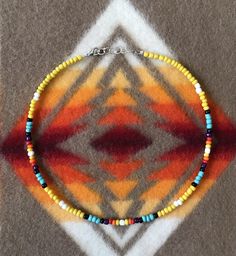 a multicolored beaded necklace is displayed on a carpet