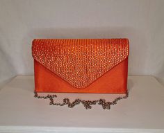 Womens orange all-over satin finish evening clutch bag with pleat detail, crystal embellished top and magnet front closing clasp Can be used with or without long shoulder chain (included) size approx- H 13cm x W 22cm Free Royal Mail delivery is an estimated 3-5 days but this can occasionally be slightly longer which solely on the Royal Mail side. We do offer guaranteed next day delivery but please contact us prior to ordering as this would incur a small upgraded shipping charge. We also offer WO Elegant Orange Clutch For Party, Orange Rectangular Clutch For Formal Occasions, Orange Clutch Bag For Formal Occasions, Orange Clutch Bag For Evening, Formal Orange Clutch Bag, Orange Rectangular Formal Clutch, Elegant Orange Rectangular Evening Bag, Elegant Orange Rectangular Clutch, Orange Clutch