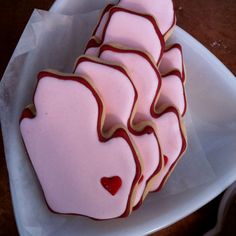 pink and red decorated cookies sitting on top of a white plate