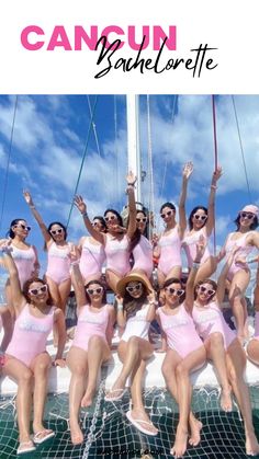 a group of women in pink bathing suits posing for a photo on a sailboat