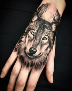 a person's hand with a wolf tattoo on it