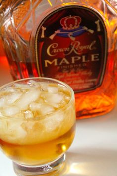 a glass filled with ice next to a bottle