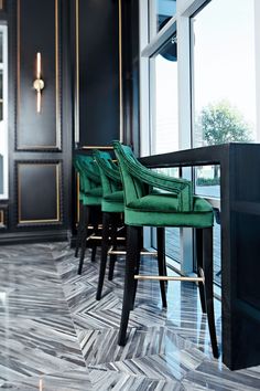 three green chairs sitting on top of a wooden table in front of a large window