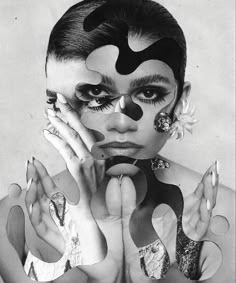 a black and white photo of a woman with her hands on her face, wearing makeup