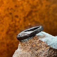 a black ring sitting on top of a rock