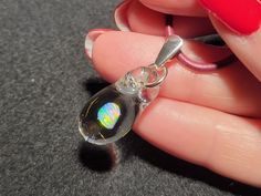 "Dive into the depths of the ocean with my dainty Mermaid's Tears pendant! This gorgeous small hand-blown teardrop pendant is made with only the highest quality borosilicate glass and features a mesmerizing Gilson opal polished nugget that shimmers with blue, green, yellow, orange and even a hint of red within the opal encased in glass. I carefully hand blow each pendant by melting the glass tubing with the Gilson opal inside within a bubble at the end.  I then condense the bubble to a solid form into the  perfect teardrop shape. This must be done slowly to completely encase the  Gilson opal within the glass to create a stunning, one-of-a-kind piece that's truly unique. The tiny boro pendant measures .8\" x .4\"  but with the bail the whole pendant dangles 1.2\".  This petite  pendant come Silver Opal Drop Jewelry, Opal Choker, Art Glass Jewelry, Mermaid Tears, Choker Pendant, Gone Forever, Necklace Design, The Bubble, Teardrop Pendant