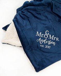 two personalized blankets on top of each other, one with the bride and groom's initials