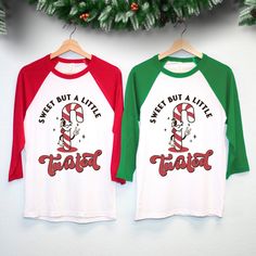 "\"Sweet But A Little Twisted\" Candy cane Women's Christmas Shirt Baseball Tee This shirt combines festive charm with a touch of humor, making it the perfect choice for those who love to add a twist to their holiday style. 🍭🎄 Available In Sizes S, M, L, Xl, 2Xl  These Run True To Size. We Recommend Sticking With Your Normal Shirt Size For These  Color: Red Sleeves, Green Sleeves Cotton & Polyester Blend Very Soft And Comfy Thank you so much for viewing this listing. Communication is my top pr Christmas White Tops With Funny Print, White Top With Funny Christmas Print, White Christmas Tops With Funny Print, White Christmas Top With Funny Print, Christmas Crew Neck Top With Funny Print, Cute Christmas T-shirt With Letter Print, White Pre-shrunk Christmas Tops, Funny Long Sleeve Christmas T-shirt, Funny Long Sleeve Christmas Tops