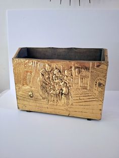 an old wooden box with carvings on the front and sides sitting on a white surface