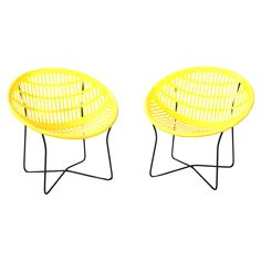 two yellow chairs sitting next to each other on top of metal bases with black legs