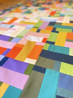 a multicolored quilt is laying on the floor